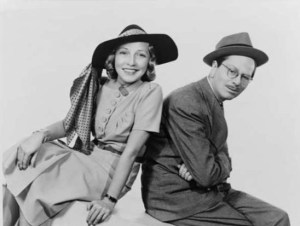 Publicity portrait of the fashionably hatted Jane and bespectacled Goodman