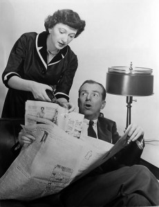 Peg clipping coupons while Alan tries to read the paper.