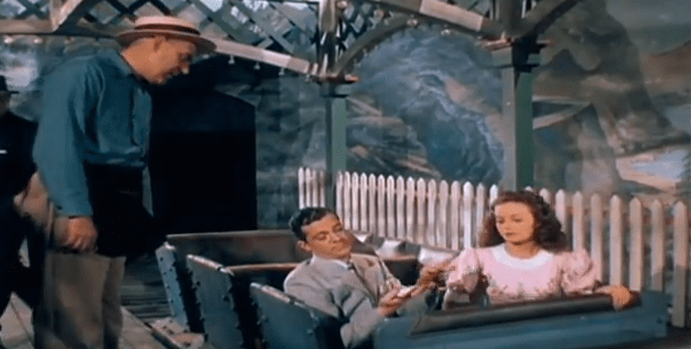 Reporter and girl share a roller coaster seat